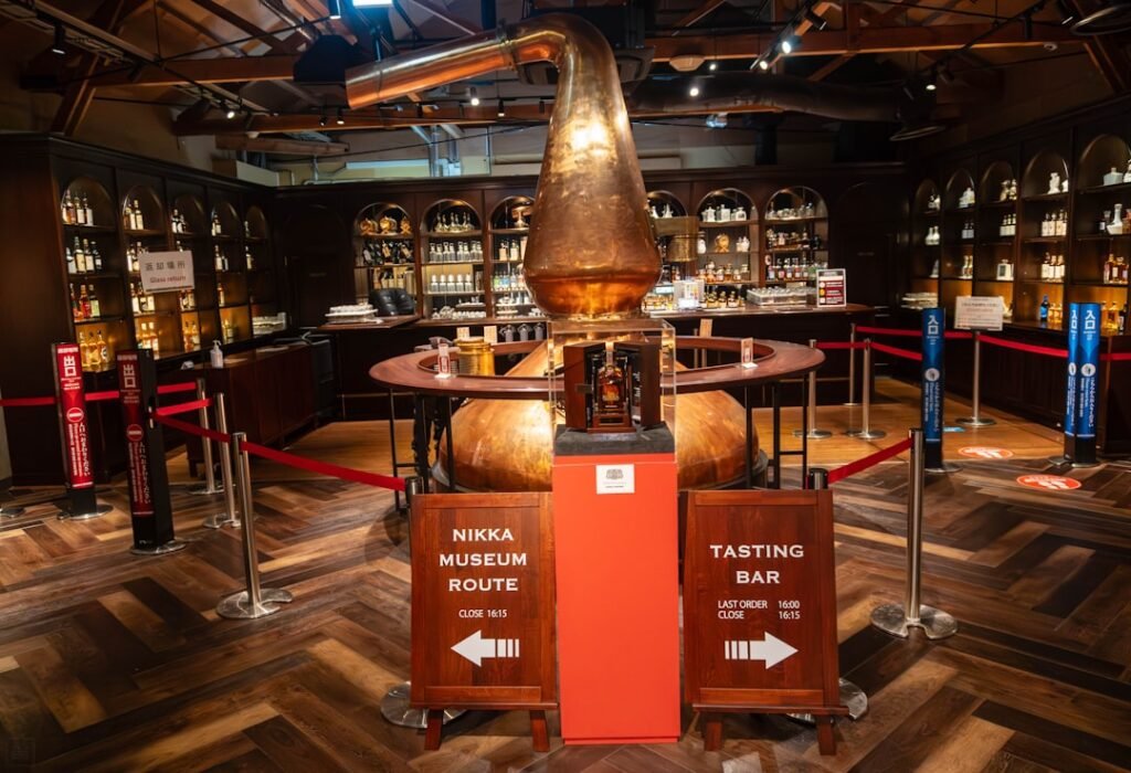 Copper still and bottles displayed in a whiskey museum.