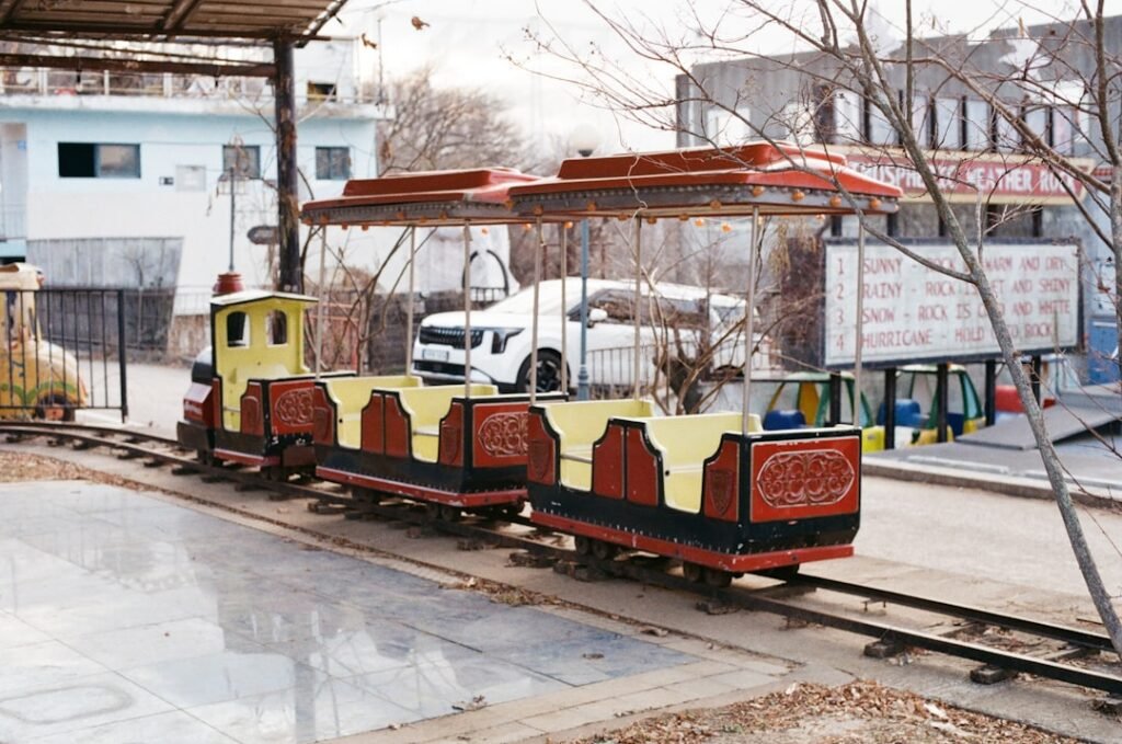 A small train on a track near a building